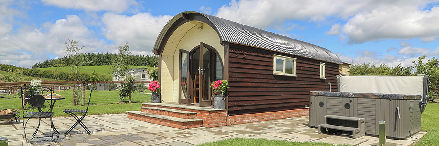 Glamping pod with a patio and a hot tub outside