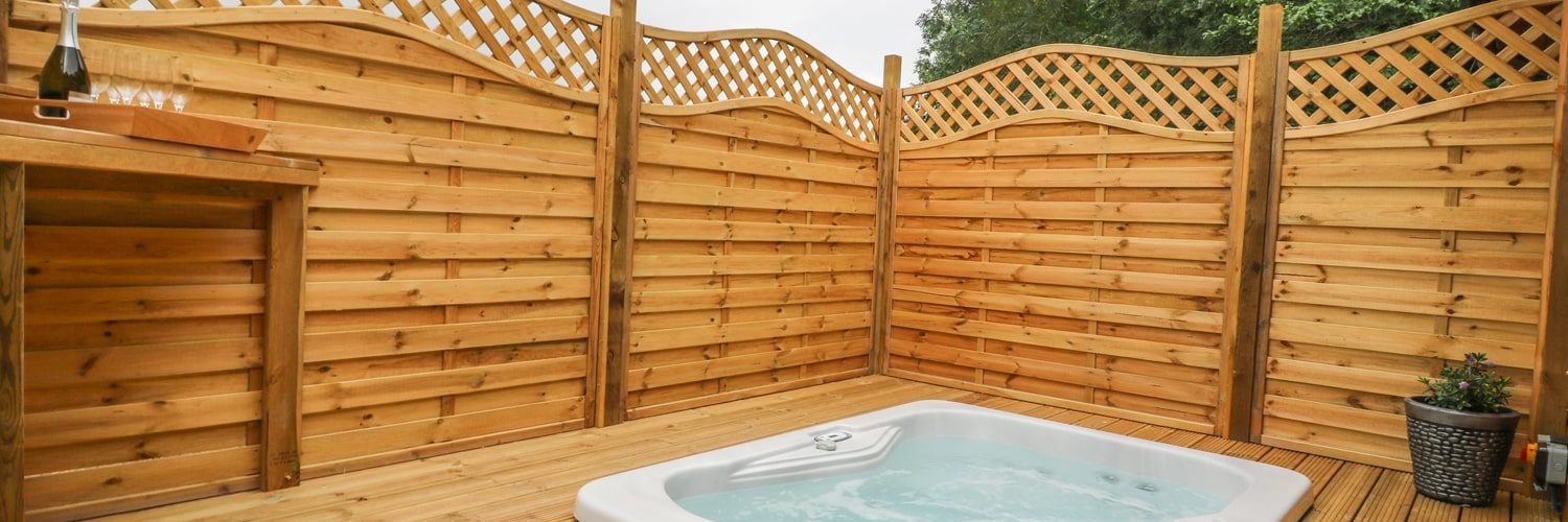 Sunken hot tub surrounded by a fence