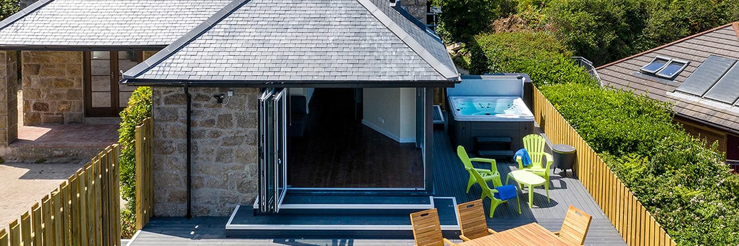 Stone cottage with large outdoor space with table and a hot tub